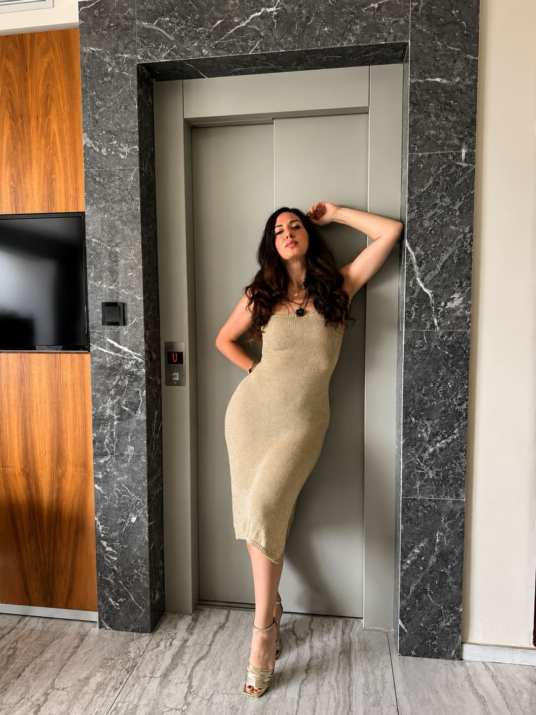 Samantha davanti a un ascensore, in un momento di passaggio e cambiamento